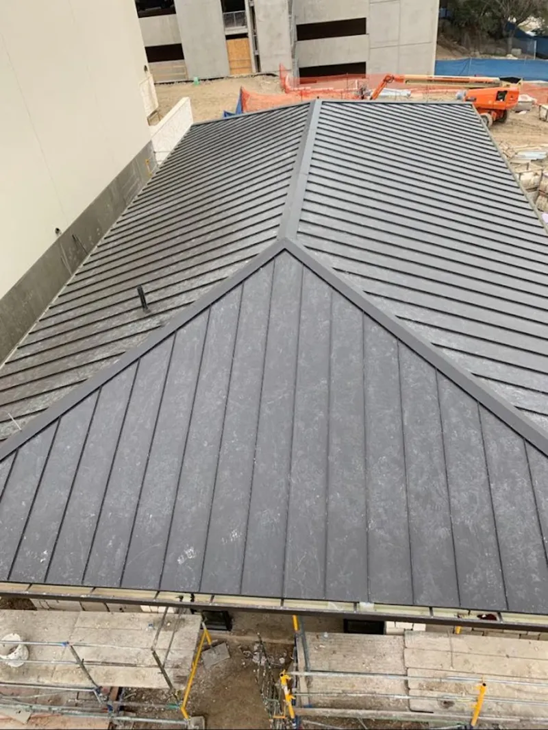 Commercial metal roof construction with crane equipment in Delray Beach